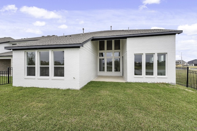 back of house featuring a lawn and a patio