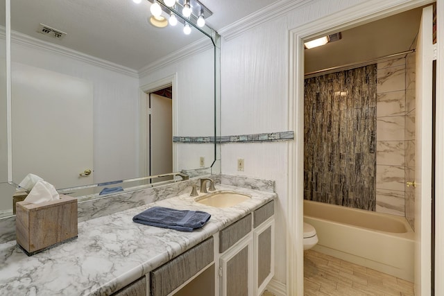 full bathroom with tiled shower / bath combo, toilet, crown molding, and vanity