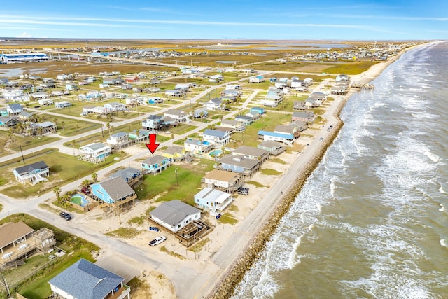 aerial view with a water view and a beach view