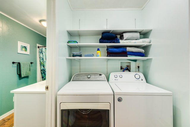 clothes washing area with washer and clothes dryer, ornamental molding, and hardwood / wood-style flooring