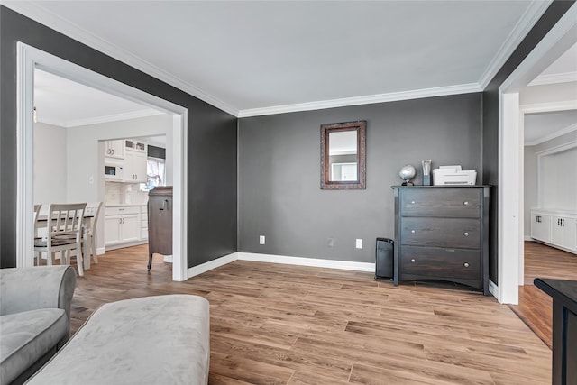 sitting room with light wood-type flooring and crown molding