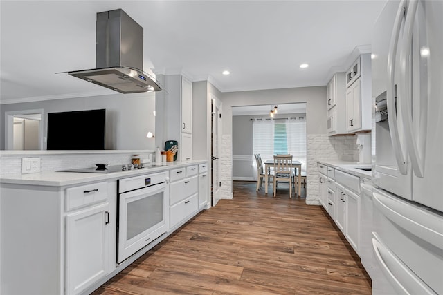 kitchen featuring extractor fan, white cabinets, backsplash, and white appliances