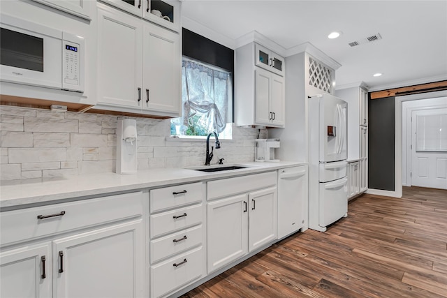 kitchen with white cabinets, dark hardwood / wood-style flooring, sink, and white appliances