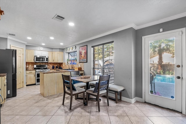 tiled dining space with ornamental molding and a textured ceiling