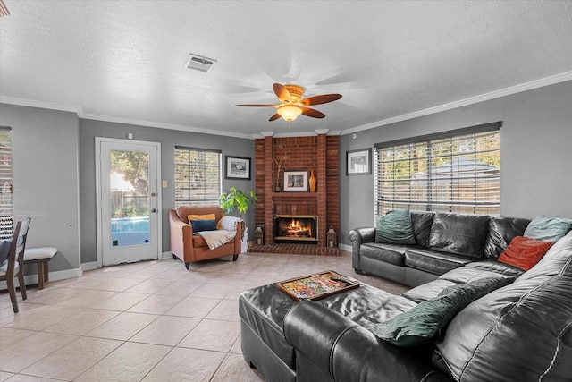 tiled living room with ornamental molding, a textured ceiling, a brick fireplace, and a healthy amount of sunlight