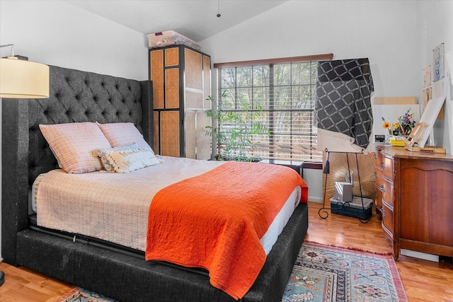 bedroom with light hardwood / wood-style flooring and lofted ceiling