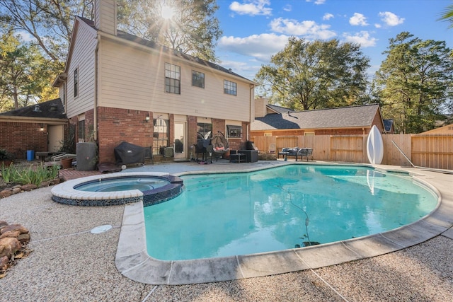 view of swimming pool featuring an in ground hot tub, a patio, area for grilling, and a water slide