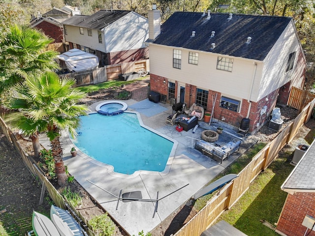 view of pool featuring an in ground hot tub, an outdoor fire pit, a patio, and central AC