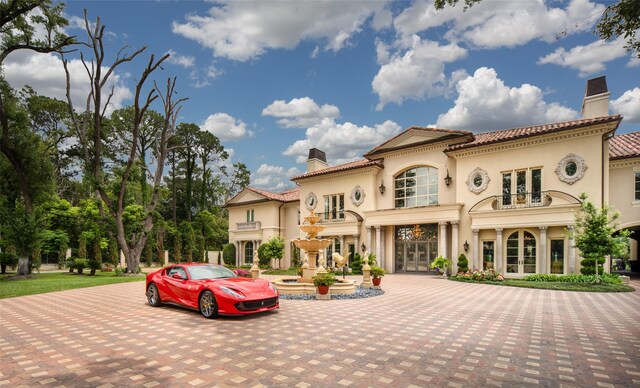 mediterranean / spanish house with french doors and a balcony