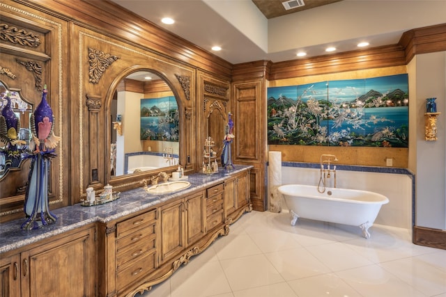 bathroom with tile patterned flooring, ornamental molding, vanity, and a tub