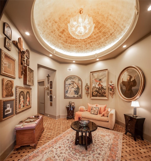 sitting room featuring an inviting chandelier and a tray ceiling