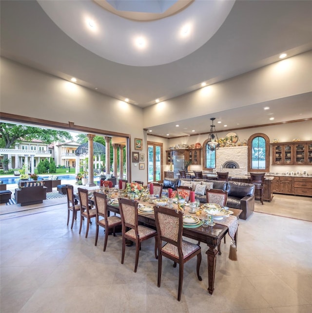 dining room featuring a towering ceiling and a wealth of natural light