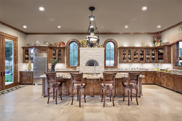 kitchen with built in fridge, plenty of natural light, and a kitchen bar