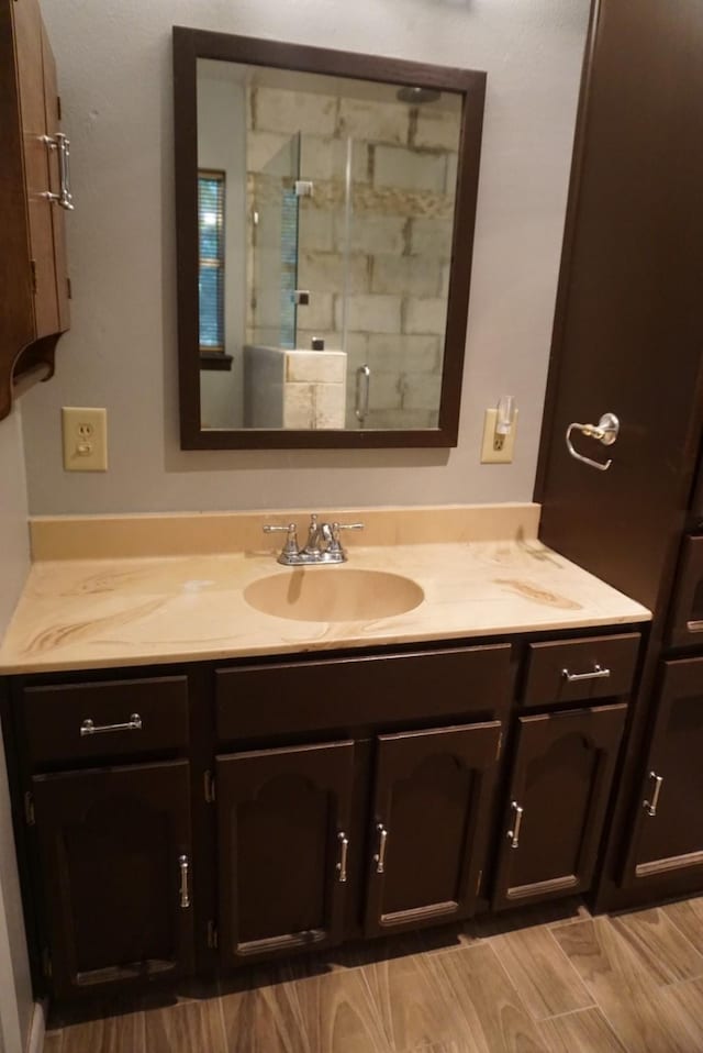 bathroom with vanity, wood-type flooring, and walk in shower