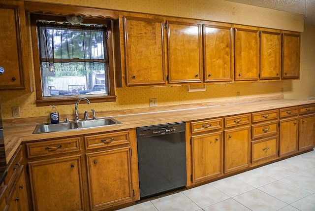 kitchen with sink, light tile patterned floors, and black dishwasher