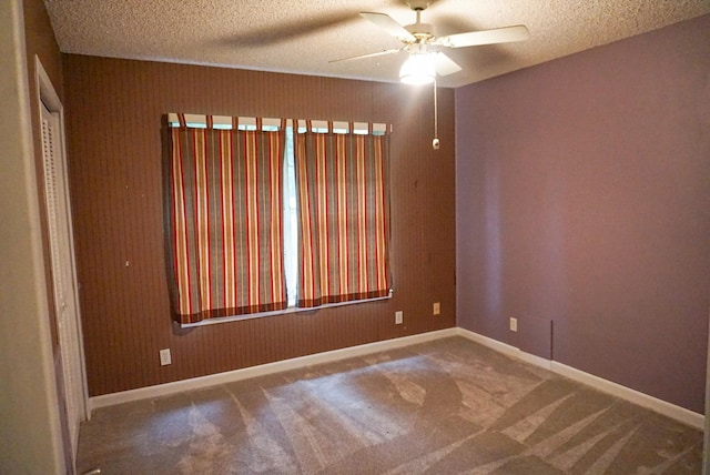 unfurnished room featuring carpet, ceiling fan, and a textured ceiling