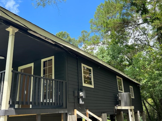 view of side of home with cooling unit and a balcony