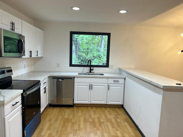 kitchen featuring kitchen peninsula, stainless steel appliances, white cabinetry, and sink