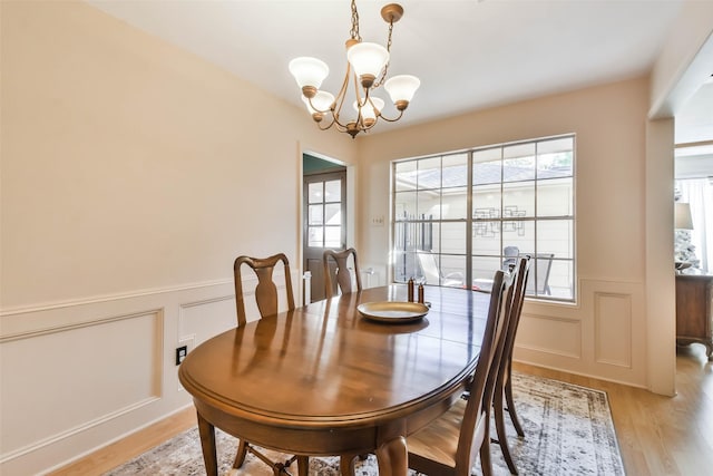 dining space featuring an inviting chandelier and light hardwood / wood-style flooring