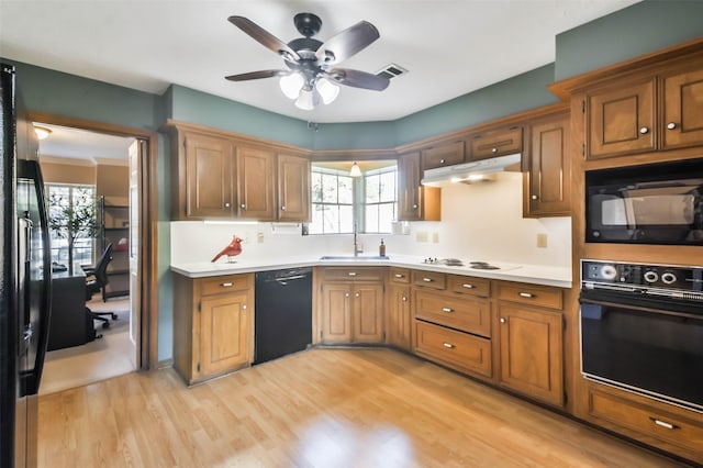 kitchen with sink, black appliances, light hardwood / wood-style floors, and ceiling fan