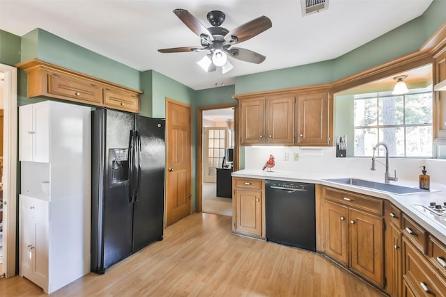 kitchen with ceiling fan, sink, light hardwood / wood-style floors, and black appliances