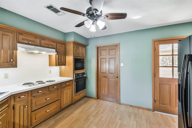 kitchen featuring ceiling fan, light wood-type flooring, and black appliances