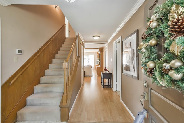 foyer with light hardwood / wood-style floors and ornamental molding