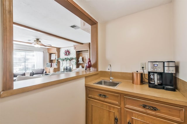 kitchen featuring beam ceiling, sink, ceiling fan, and kitchen peninsula