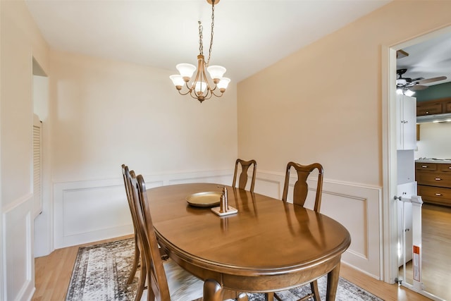 dining space featuring ceiling fan with notable chandelier and light wood-type flooring