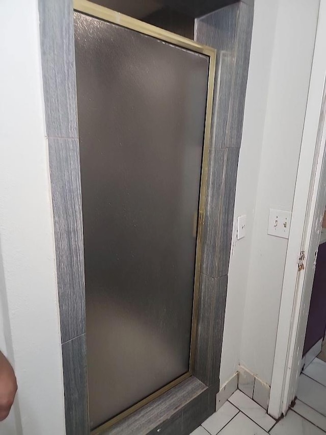 bathroom featuring tile patterned floors and a shower with door