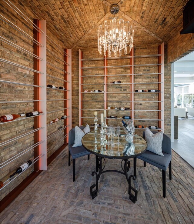 dining area featuring brick ceiling, an inviting chandelier, and lofted ceiling