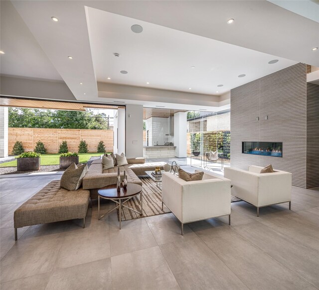 living room featuring a tray ceiling and a fireplace