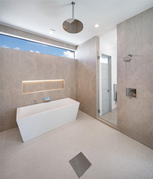 bathroom featuring a wealth of natural light and independent shower and bath