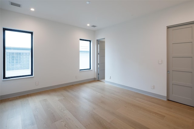 unfurnished room with light hardwood / wood-style floors and a healthy amount of sunlight