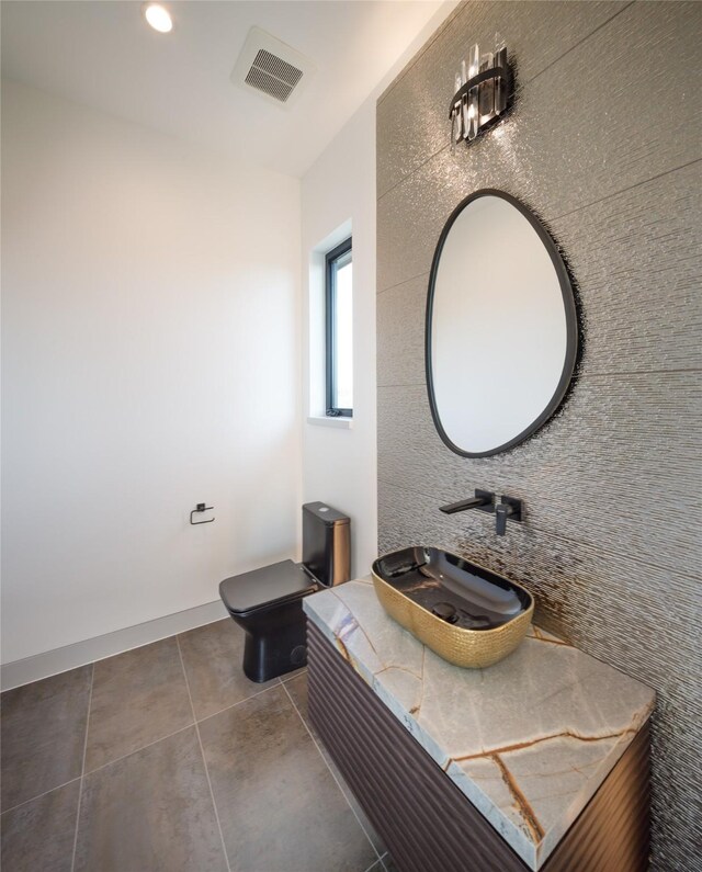 bathroom with toilet, tile patterned floors, and sink