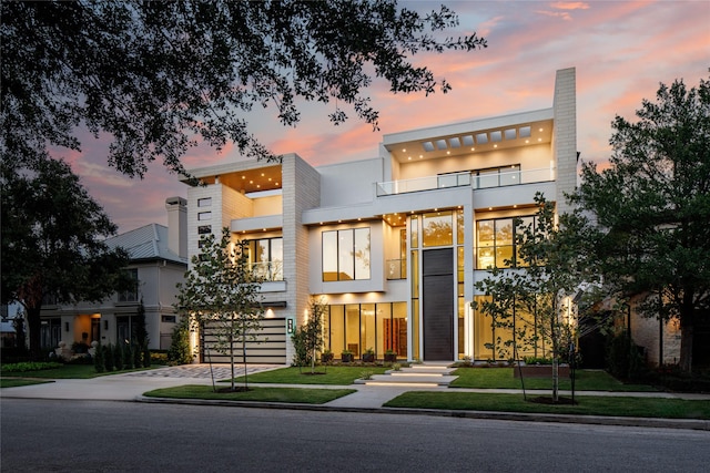 contemporary home featuring a lawn and a garage