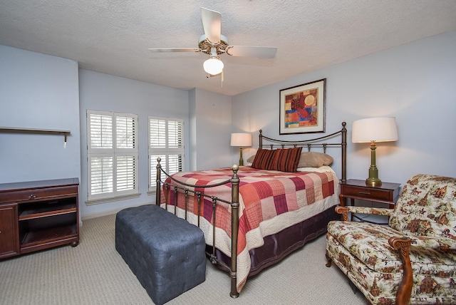 carpeted bedroom with ceiling fan and a textured ceiling