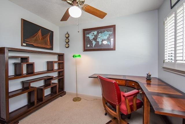 carpeted home office featuring ceiling fan, built in desk, a wealth of natural light, and a textured ceiling