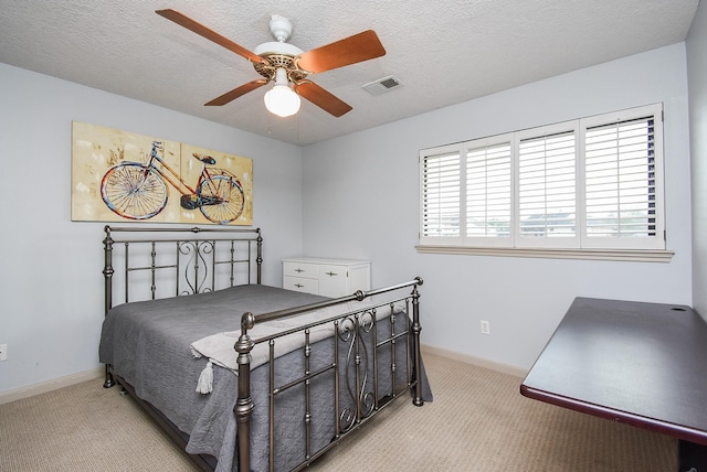 carpeted bedroom with ceiling fan and a textured ceiling