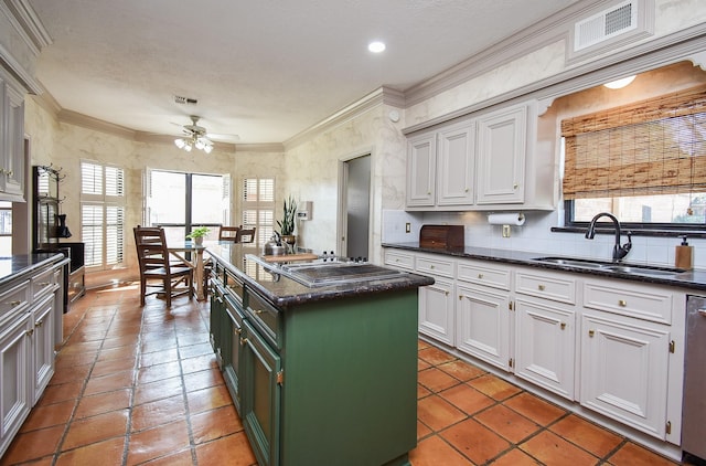 kitchen with sink, gas stovetop, white cabinetry, a center island, and green cabinets