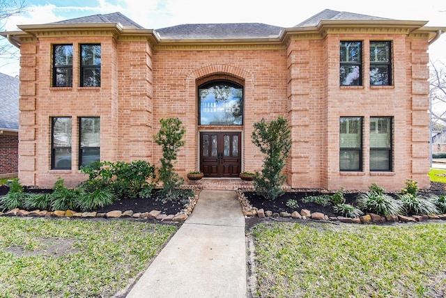 doorway to property with a lawn and french doors