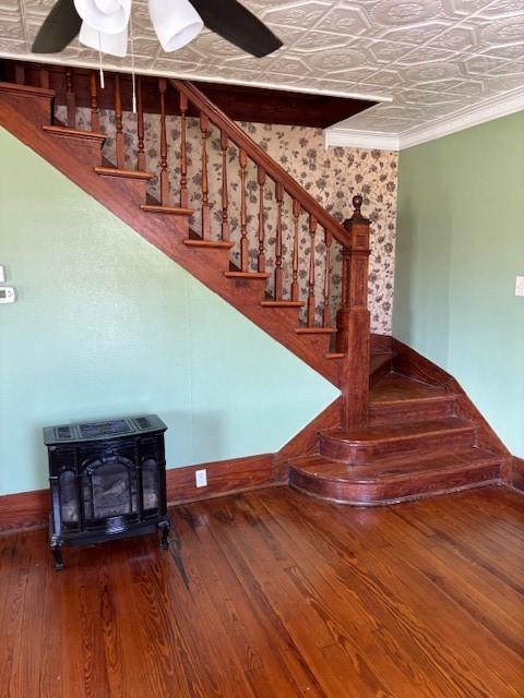 stairs featuring hardwood / wood-style flooring, ceiling fan, and crown molding