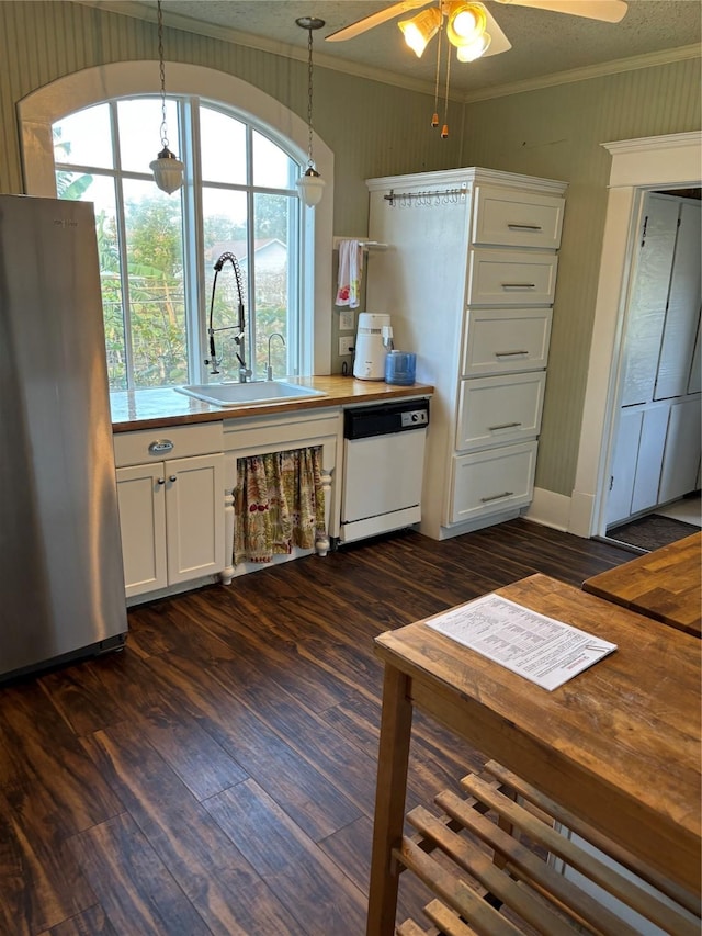 kitchen featuring sink, dark wood-type flooring, hanging light fixtures, stainless steel fridge, and white dishwasher