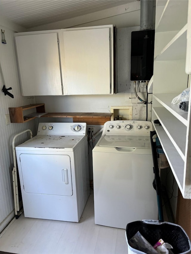 clothes washing area with cabinets and separate washer and dryer