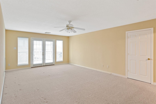 carpeted spare room featuring a textured ceiling and ceiling fan