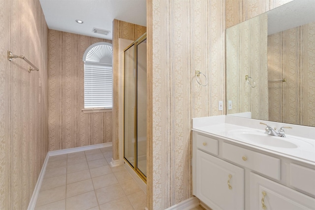 bathroom with tile patterned flooring, vanity, and walk in shower