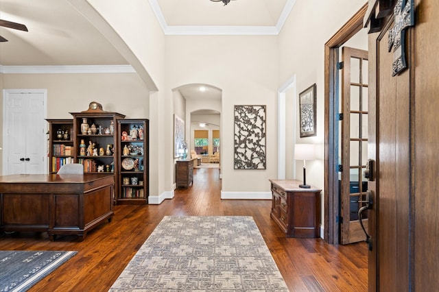 entrance foyer with a high ceiling, dark hardwood / wood-style floors, ceiling fan, and ornamental molding