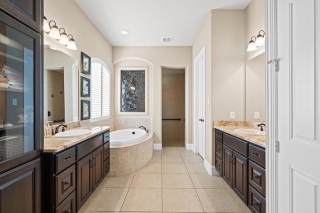 bathroom with vanity, tile patterned floors, and tiled tub