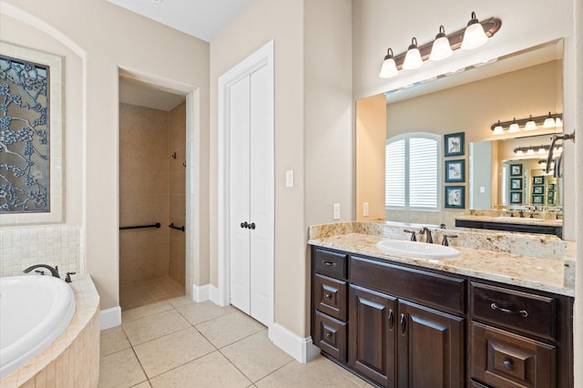 bathroom featuring tile patterned flooring, vanity, and shower with separate bathtub