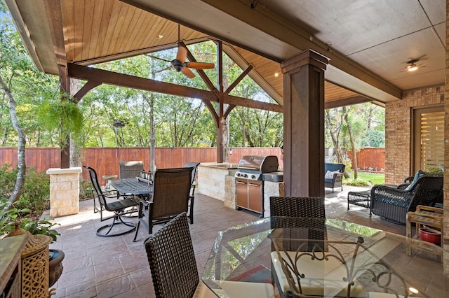 view of patio with an outdoor kitchen, an outdoor hangout area, ceiling fan, a gazebo, and grilling area